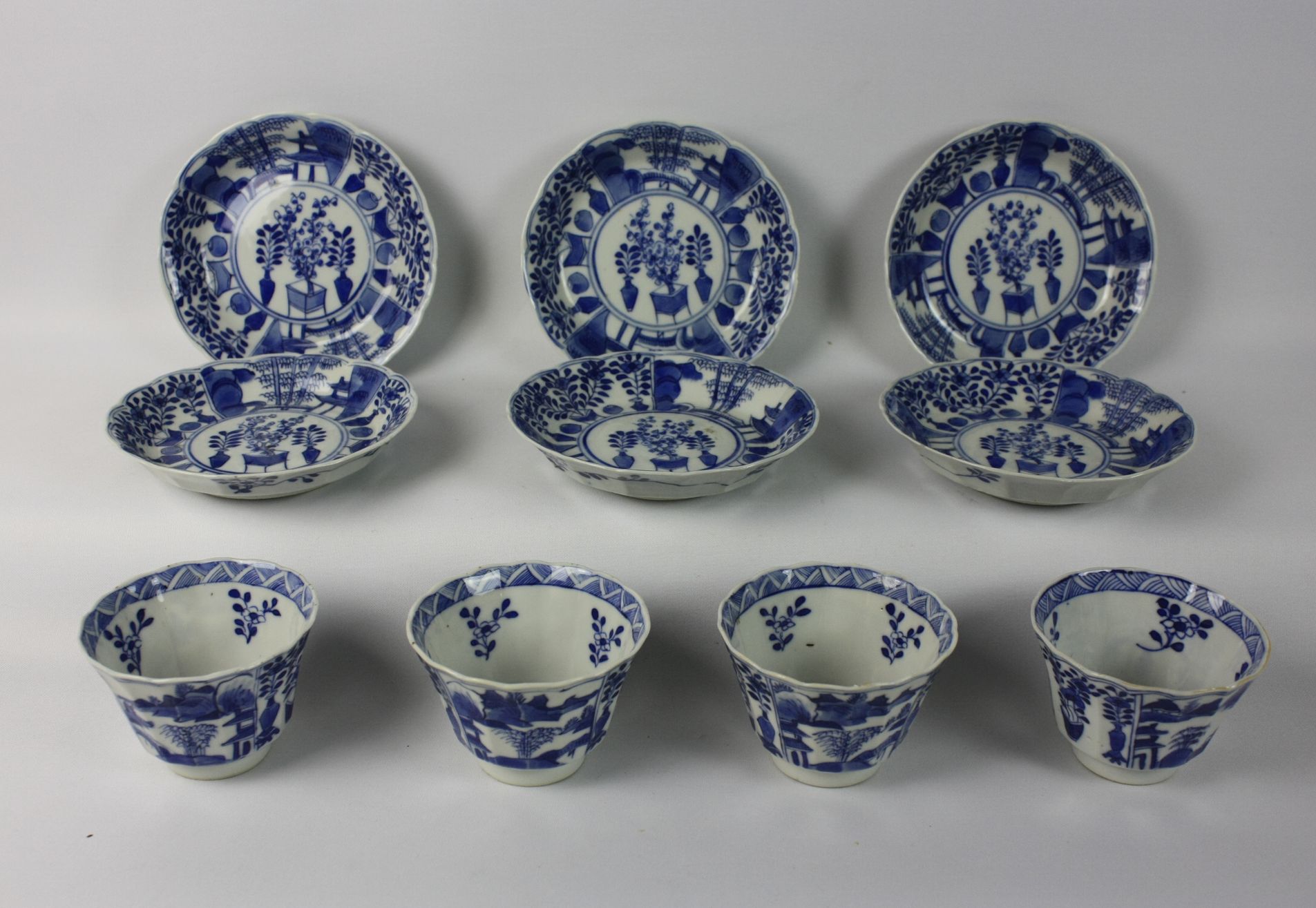 028 Een groep Chinese blauw-witte kopjes en schotels, versierd met landschappen en antiquiteiten