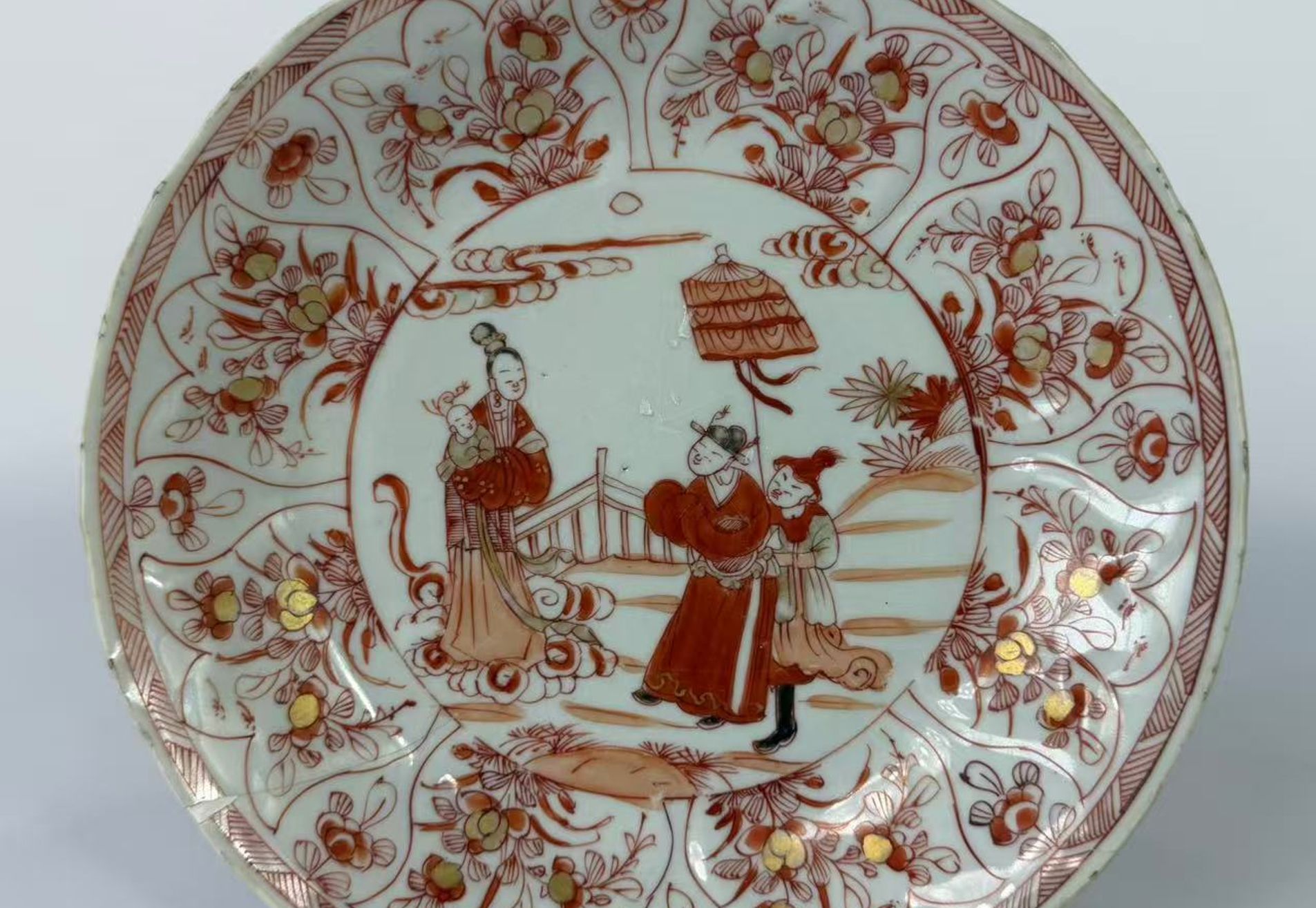 026 Een in ijzerrood en goud gedecoreerde schotel met figuren en florale motieven, Kangxi-periode (Qing-dynastie, 1662–1722)