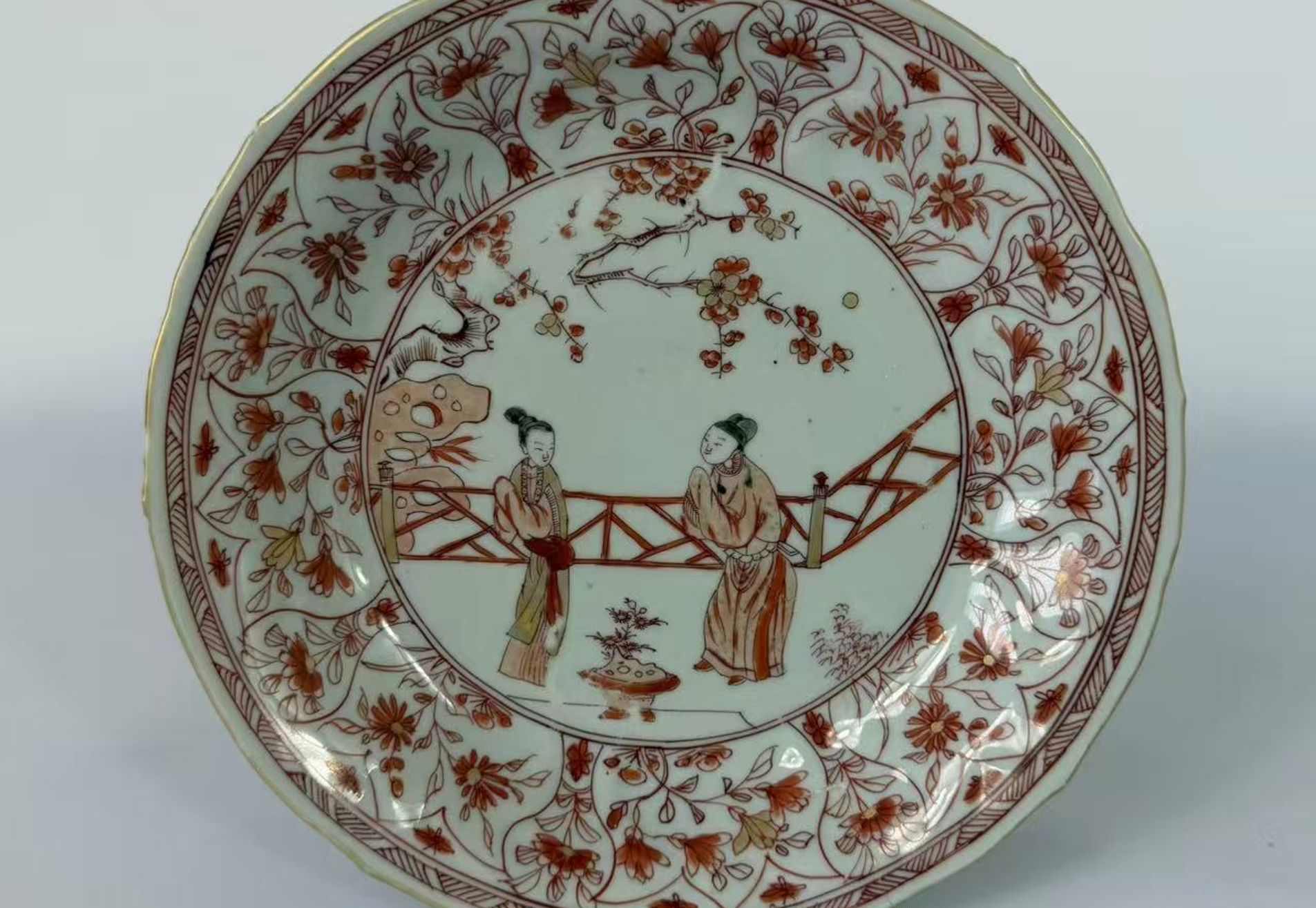 026 Een in ijzerrood en goud gedecoreerde schotel met figuren en florale motieven, Kangxi-periode (Qing-dynastie, 1662–1722)