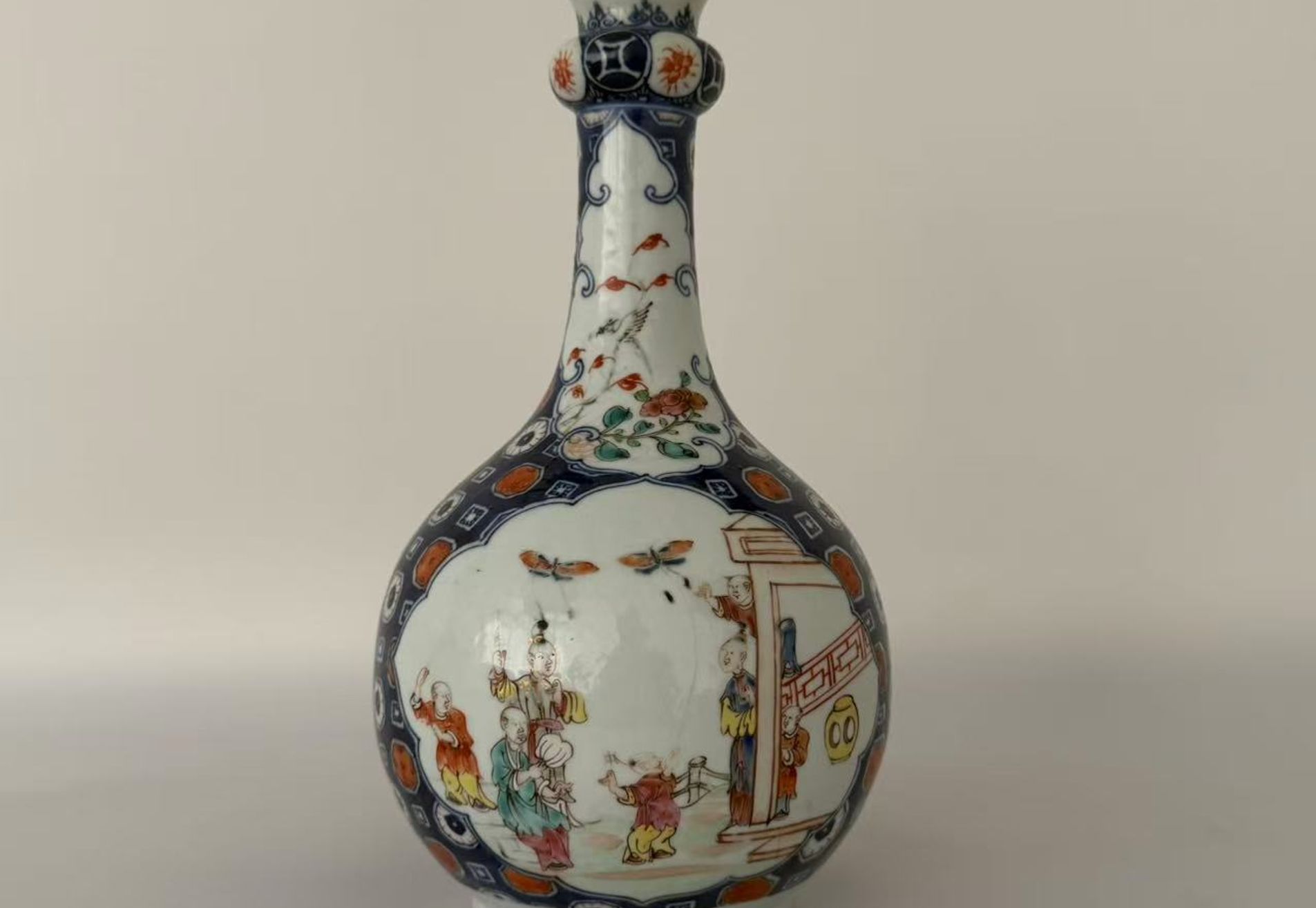 006 A Qianlong period blue-and-white and famille rose vase with iron-red and gilt decoration, featuring figural garden scenes and floral-and-bird motifs, in the form of a garlic-head bottle vase
