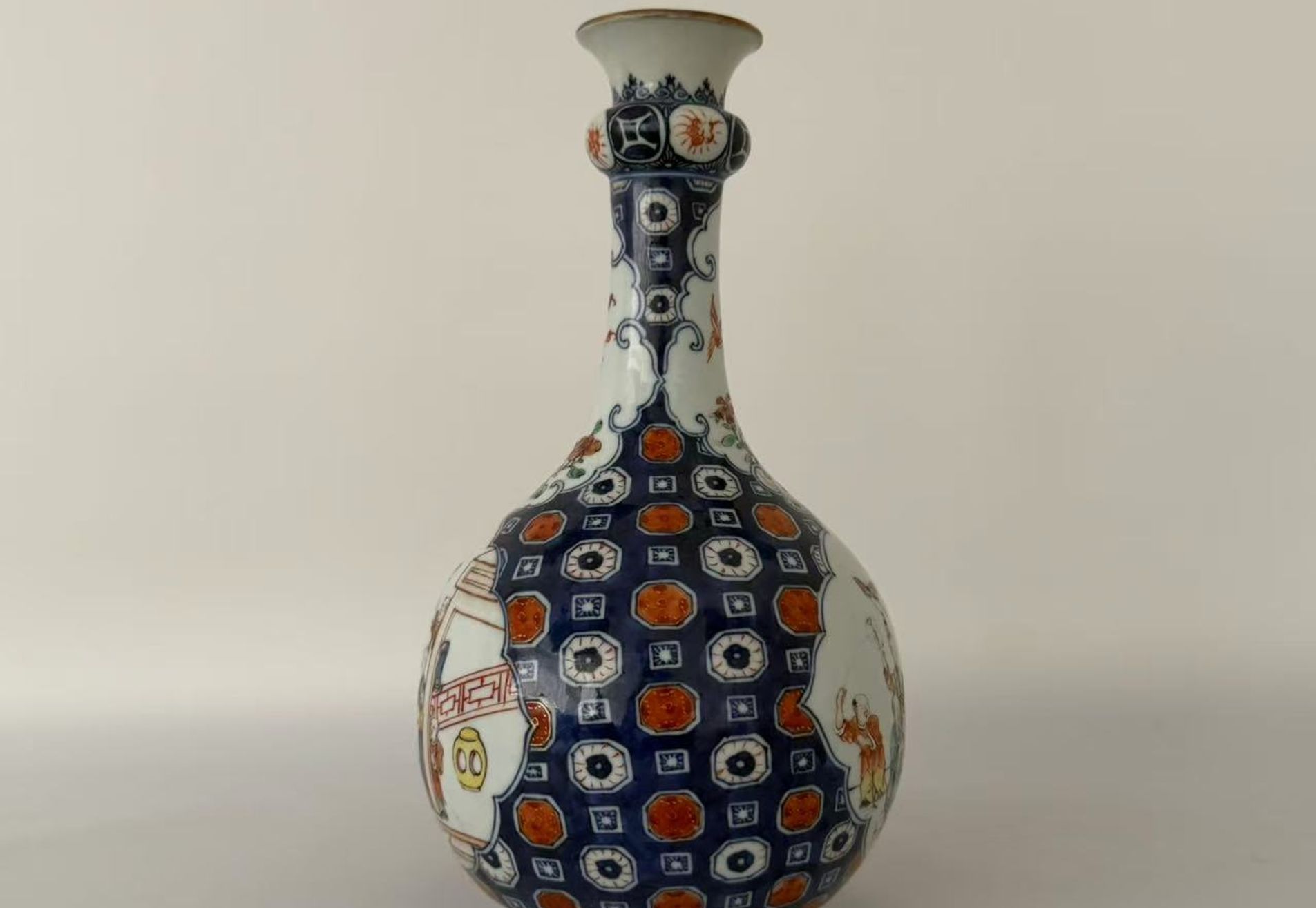 006 A Qianlong period blue-and-white and famille rose vase with iron-red and gilt decoration, featuring figural garden scenes and floral-and-bird motifs, in the form of a garlic-head bottle vase