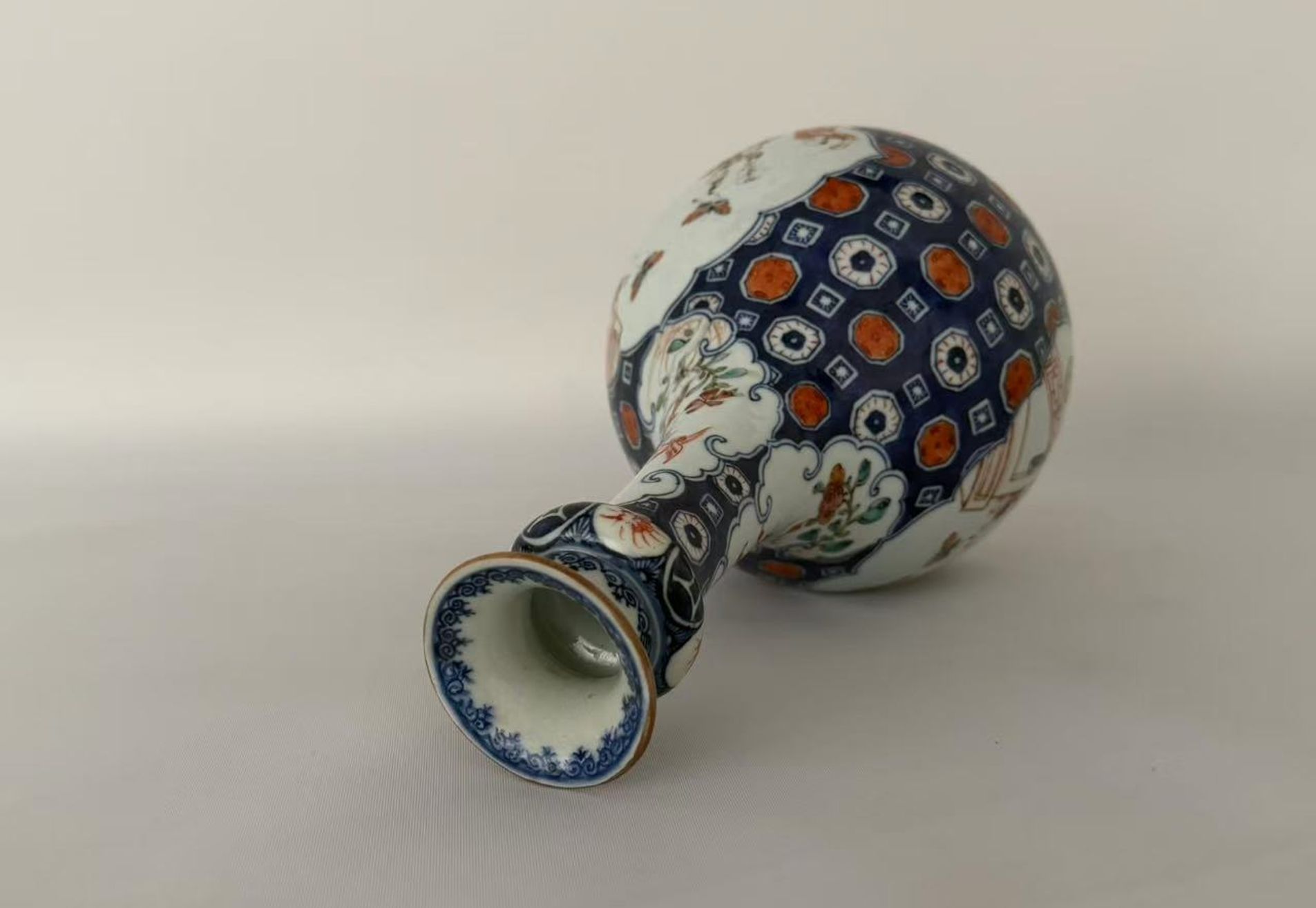 006 A Qianlong period blue-and-white and famille rose vase with iron-red and gilt decoration, featuring figural garden scenes and floral-and-bird motifs, in the form of a garlic-head bottle vase